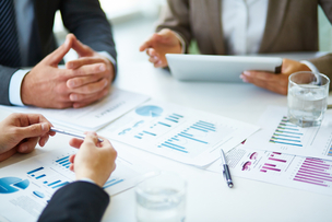 Personnes en réunion travaillant sur des documents avec des graphiques et des chiffres (image : Freepik)